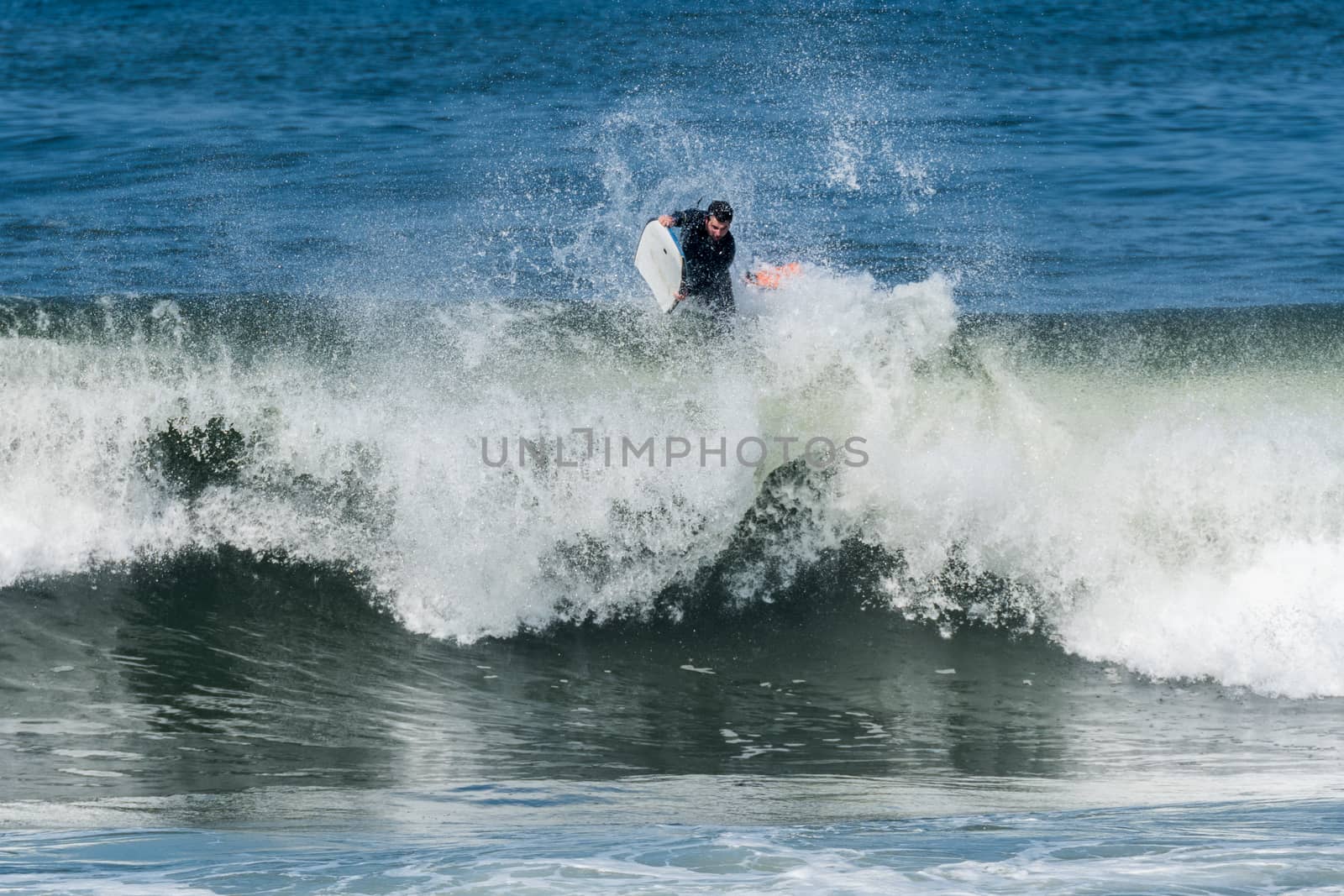 Bodyboarder in action on the ocean waves on a sunny day.