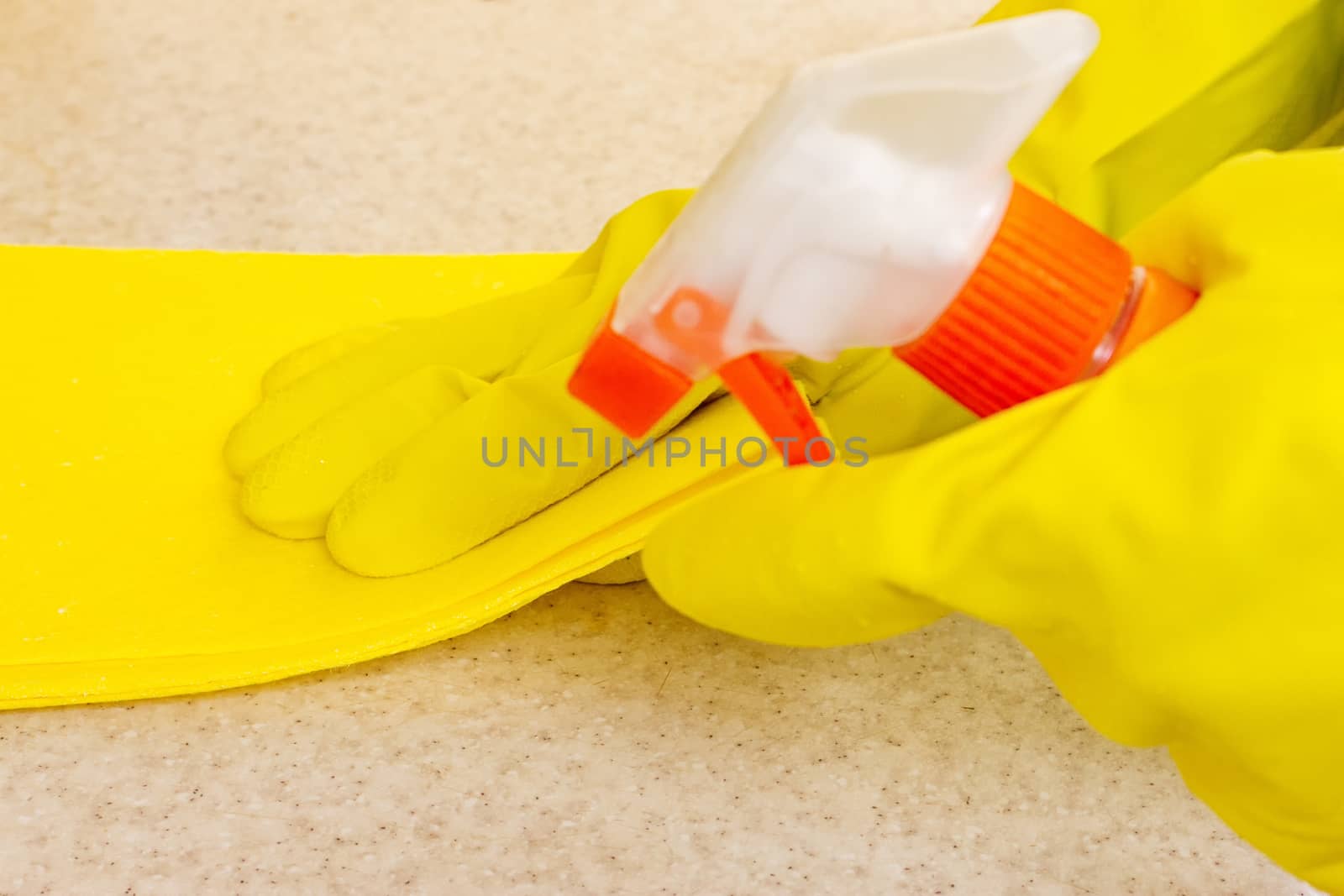 Hand in rubber glove cleans a new kitchen. Woman with housework, cleaning the kitchen.