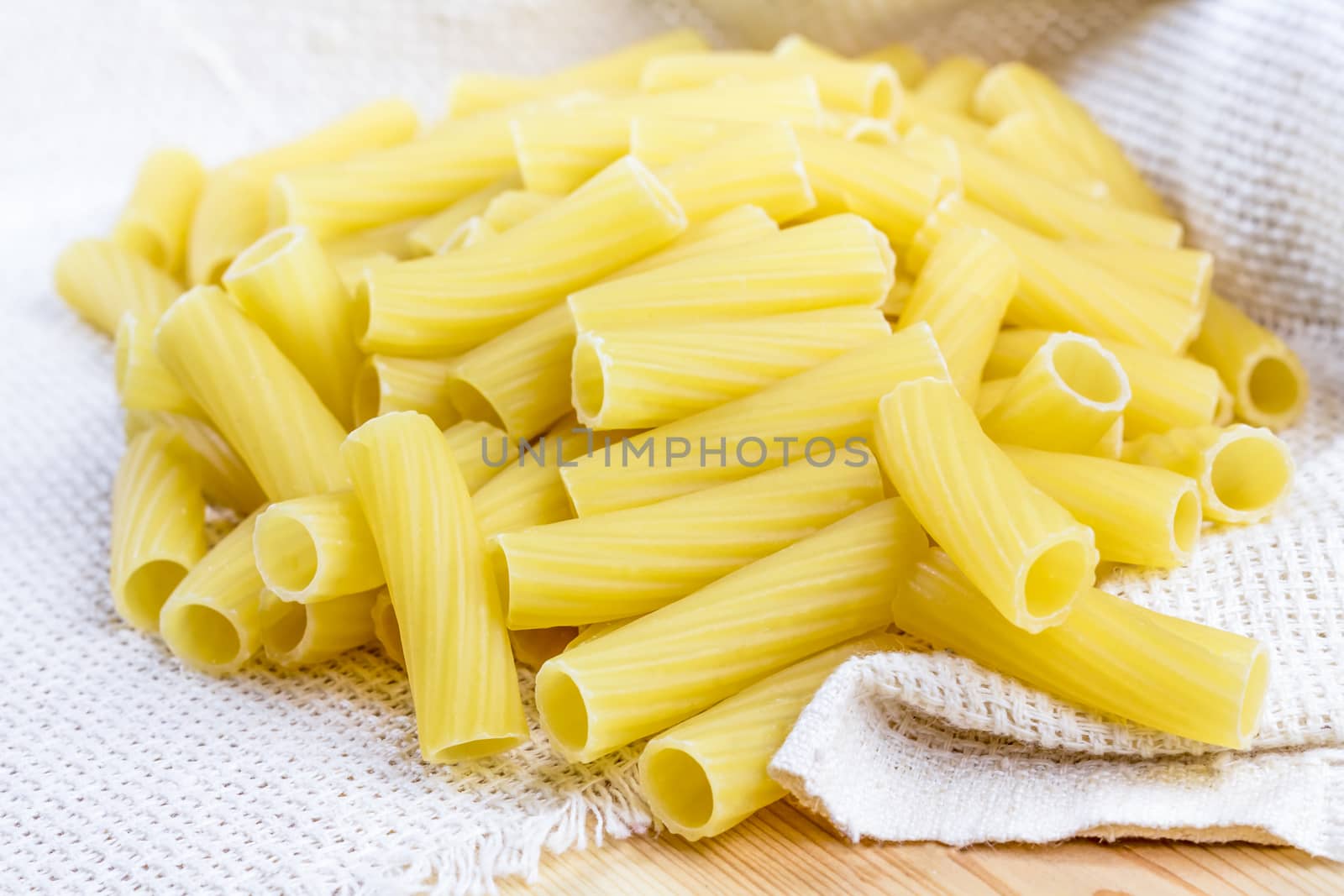 Raw uncooked tortiglioni pasta on canvas napkin