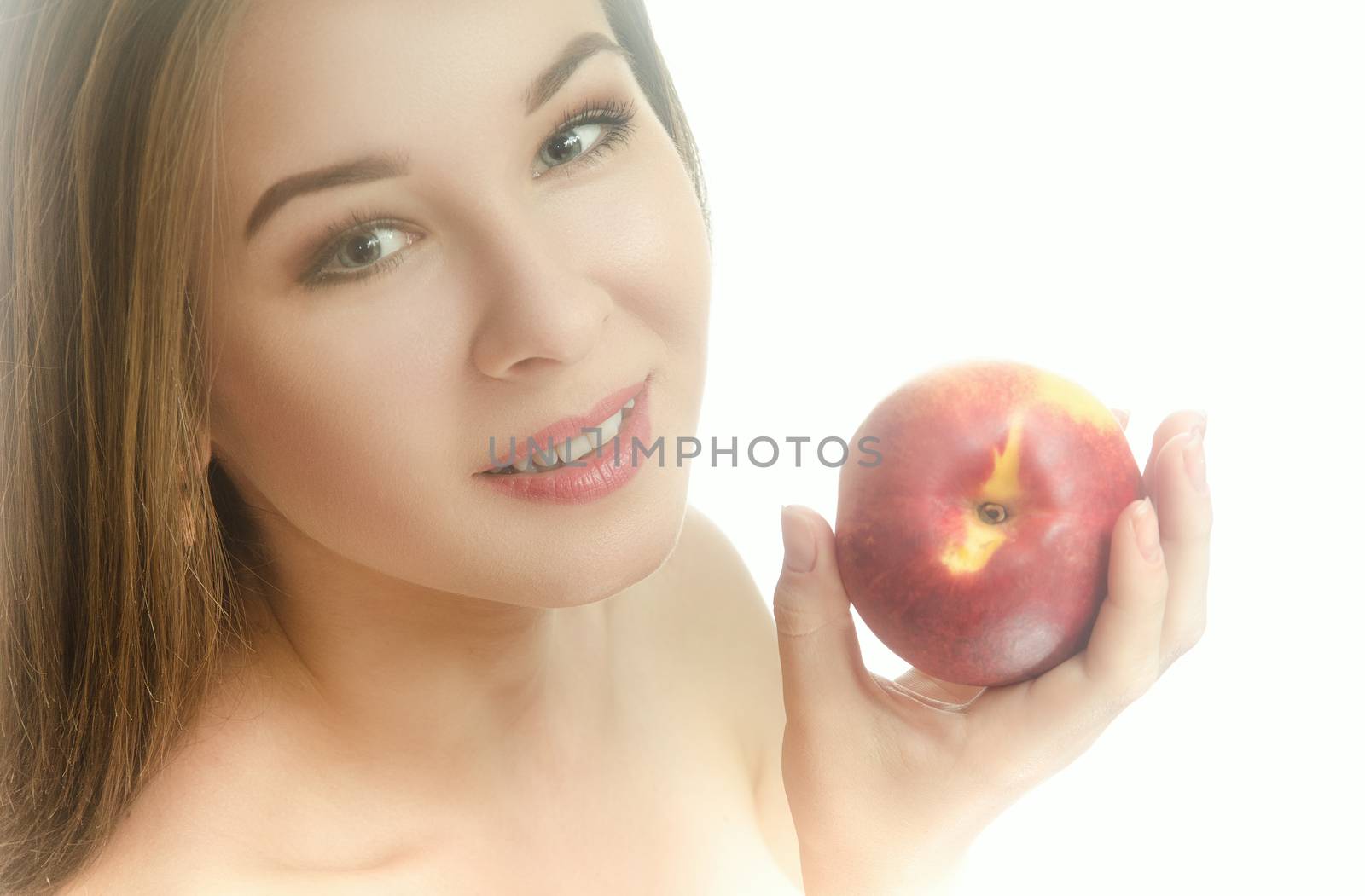 Smiling young girl with a peach in her hand on a white background. Horizontal photo