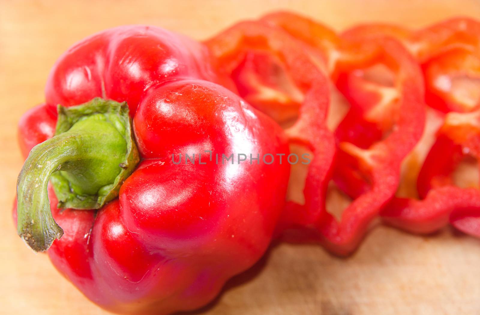 Red pepper cut by slice on a wooden background. Horizontal photo