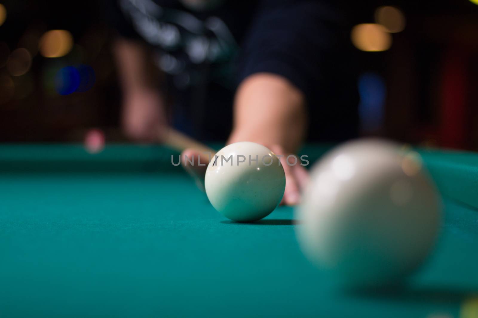 Russian billiards game in progress: player aims to shoot balls with cue