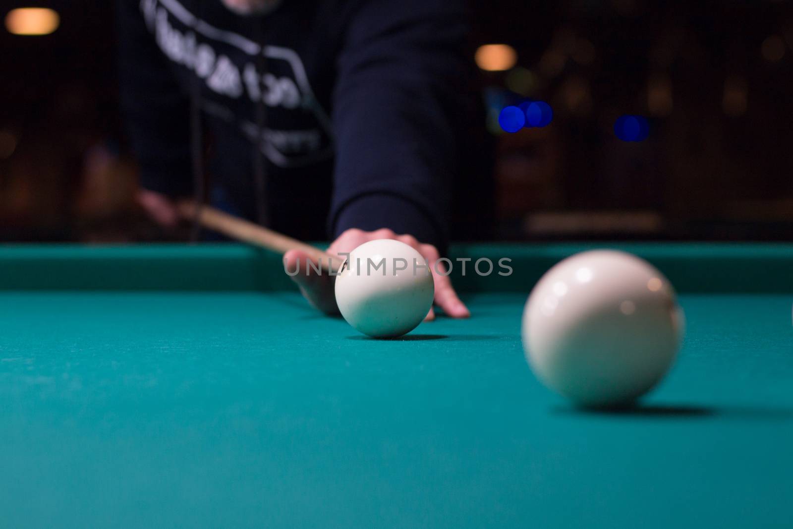 Russian billiards game in progress: player aims to shoot balls with cue