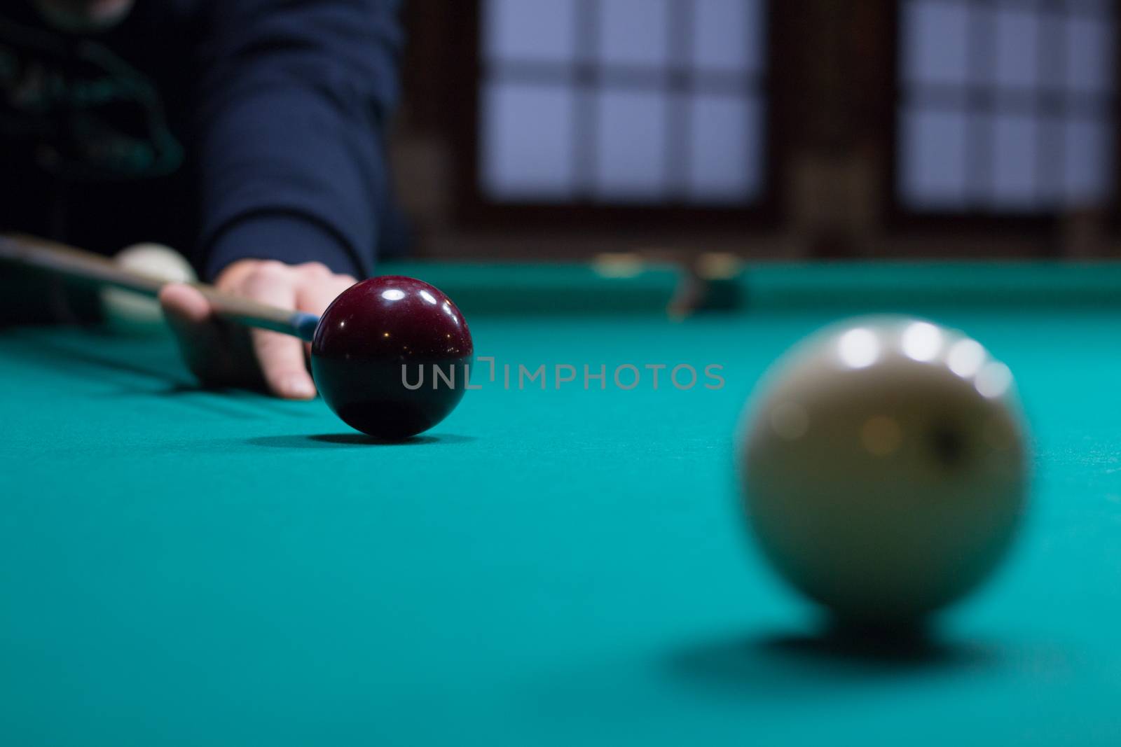 Russian billiards game in progress: player aims to shoot balls with cue