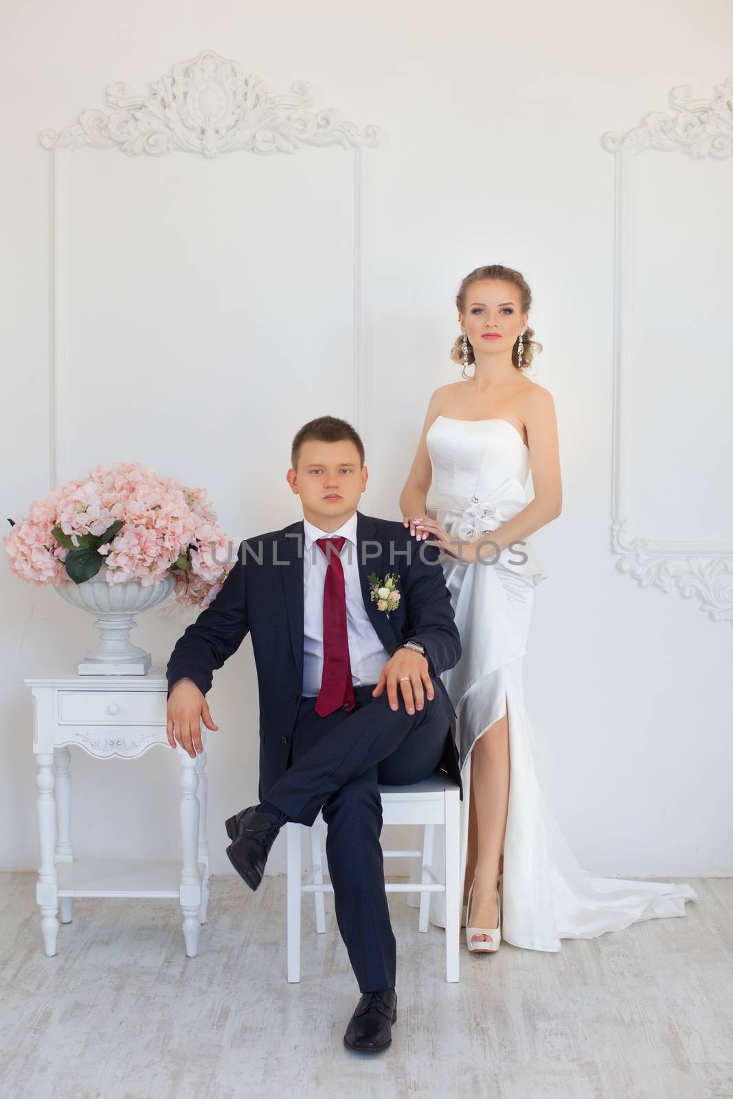 Stylish newlyweds posing for photography at the apartment