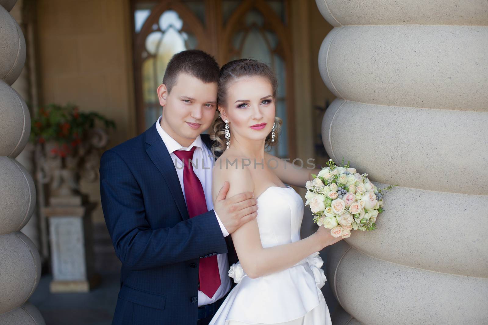 The groom gently hugged the bride standing at the column by lanser314