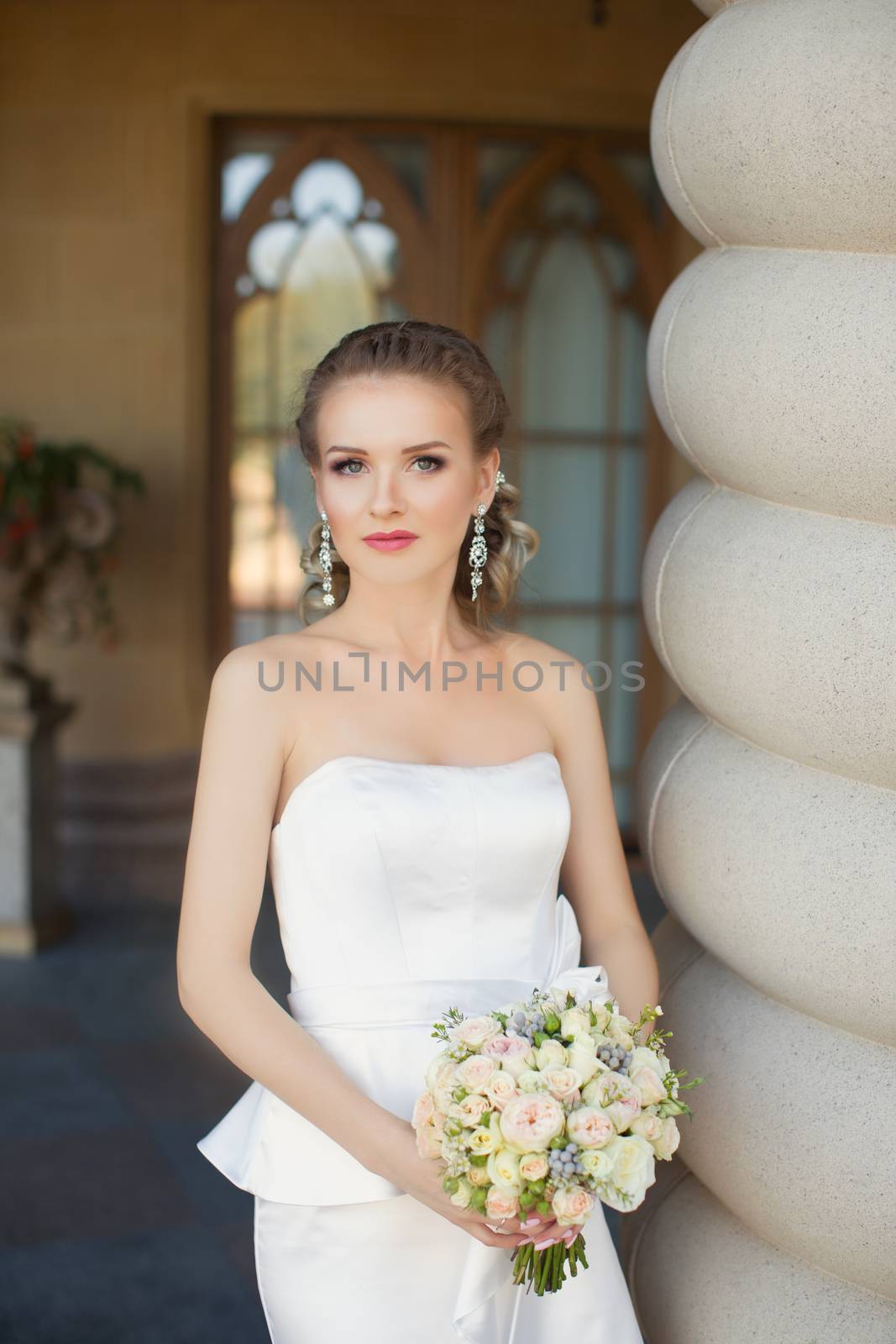 Bride in white dress posing on the photo for a walk