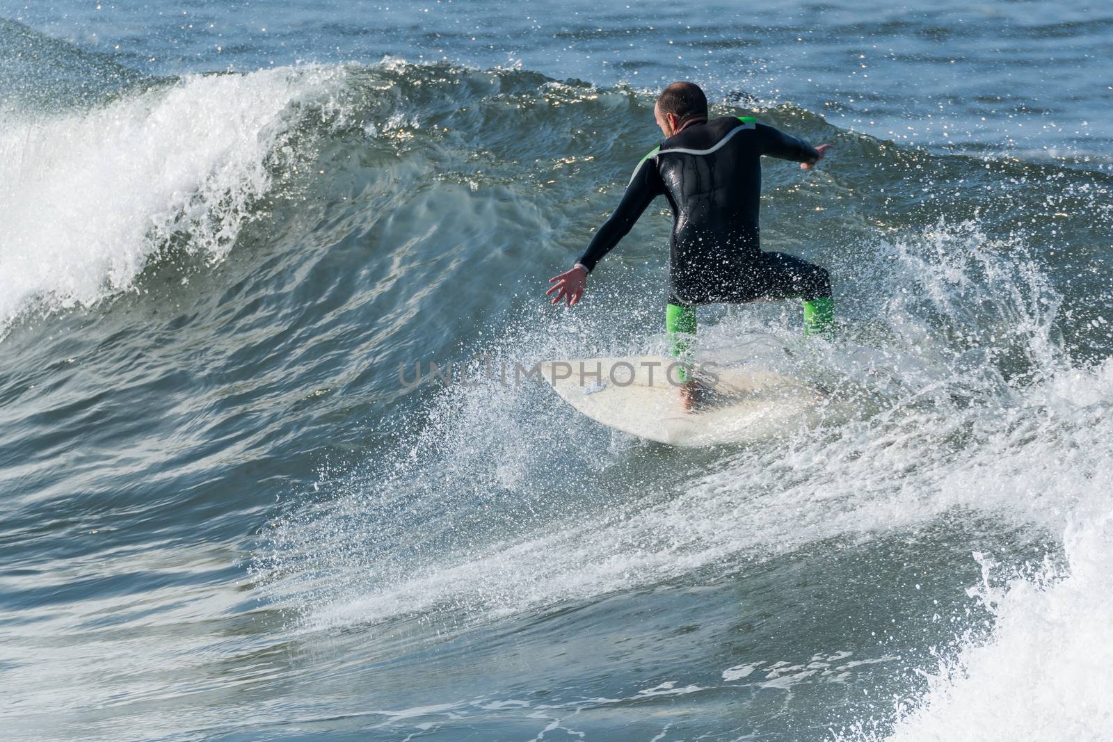 Surfer in action on the ocean waves on a sunny day.