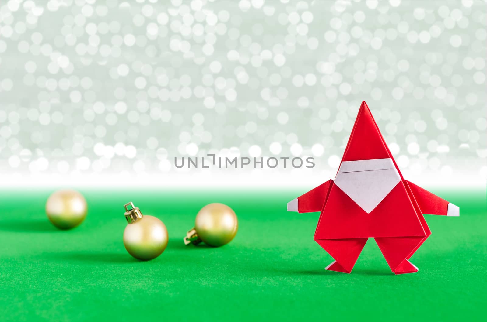 Santa Claus paper craft and golden ball with lights snow winter background. Paper origami.