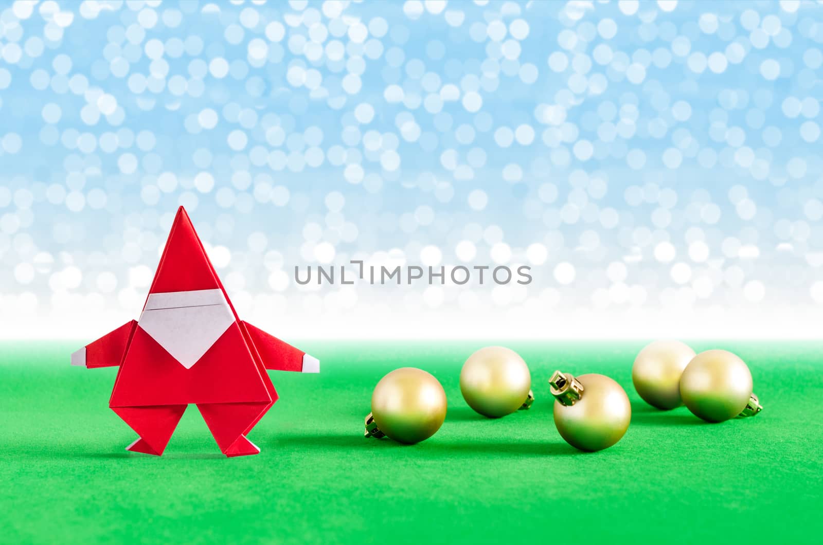 Santa Claus paper craft and golden ball with lights snow winter background. Paper origami.