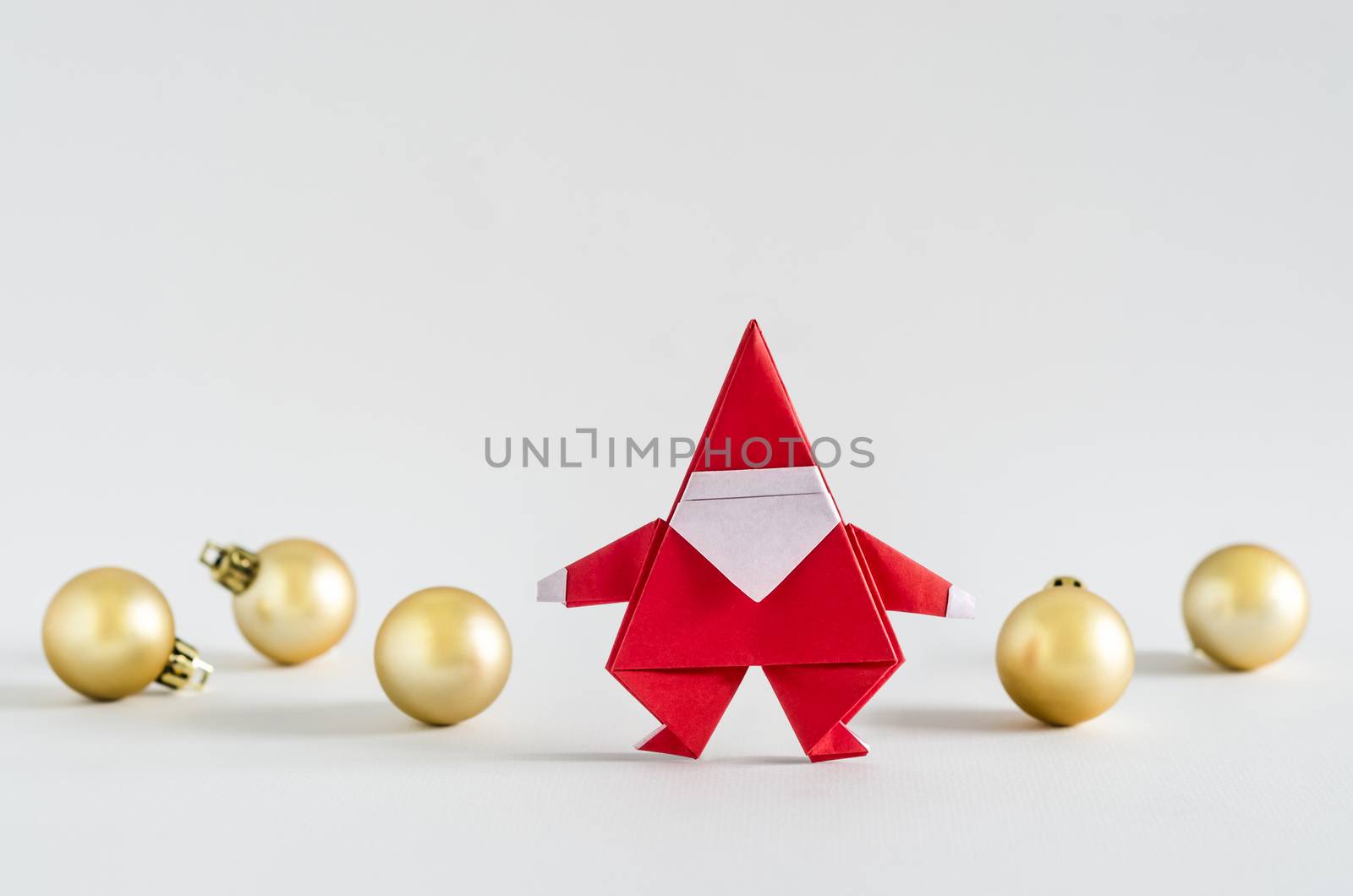 Santa Claus paper craft and golden ball on white background. Paper origami.