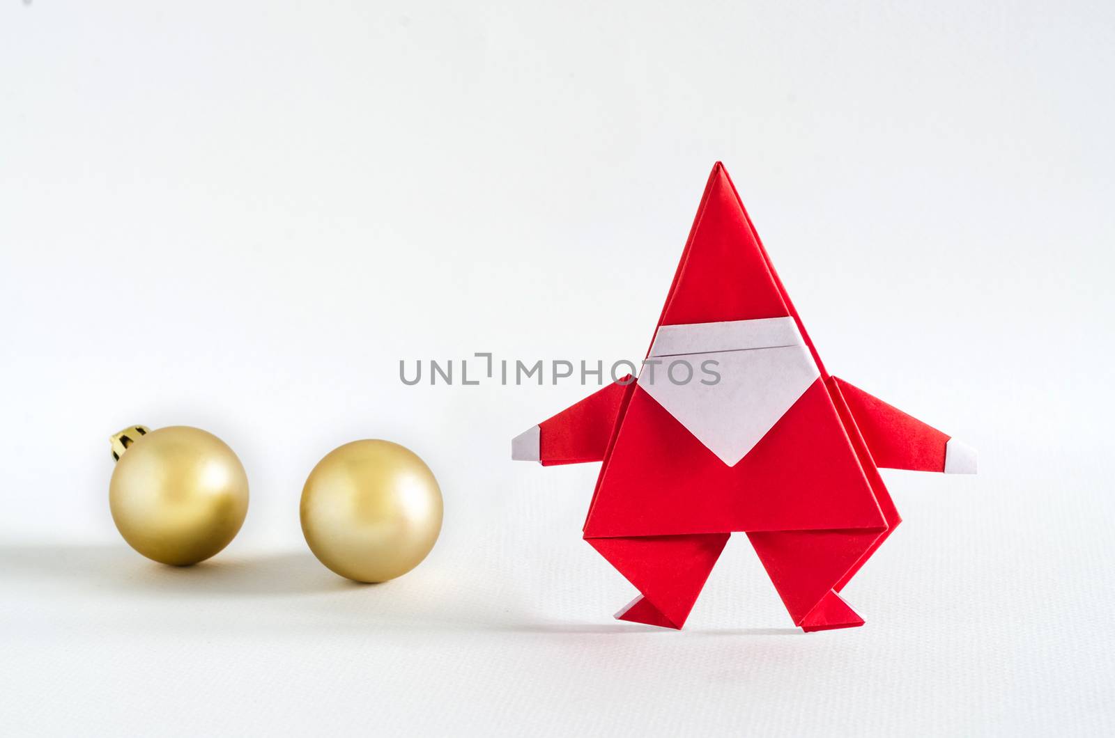 Santa Claus paper craft and golden ball on white background. Paper origami.