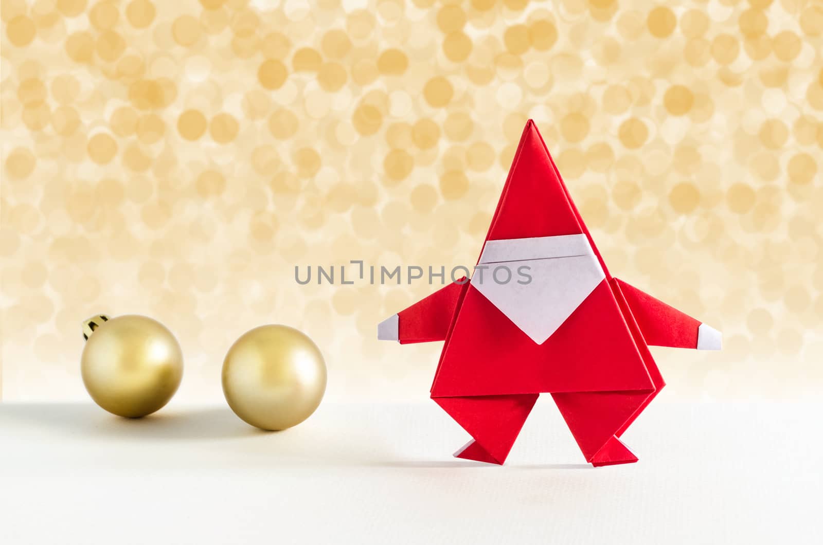 Santa Claus paper craft and golden ball with lights snow winter background. Paper origami.