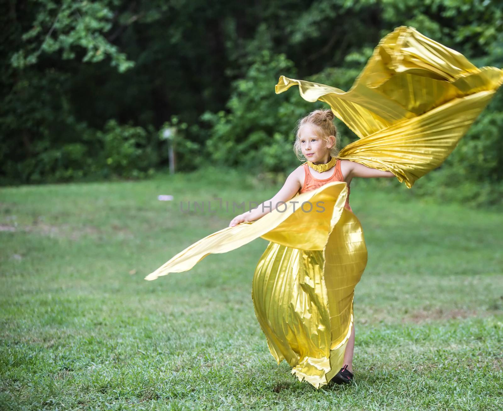HOT SPRINGS, NC - JULY 9: Cute little girl in golden angelic costume twirling and dancing at the Wild Goose Festival on July 9, 2016 in Hot Springs, NC, USA.
