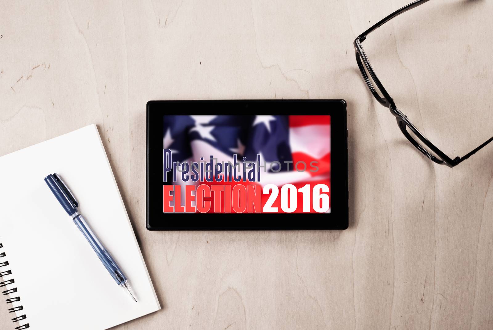 tablet with American flag on wooden table, glasses, pen and Notepad, promotion of popular elections in the United States