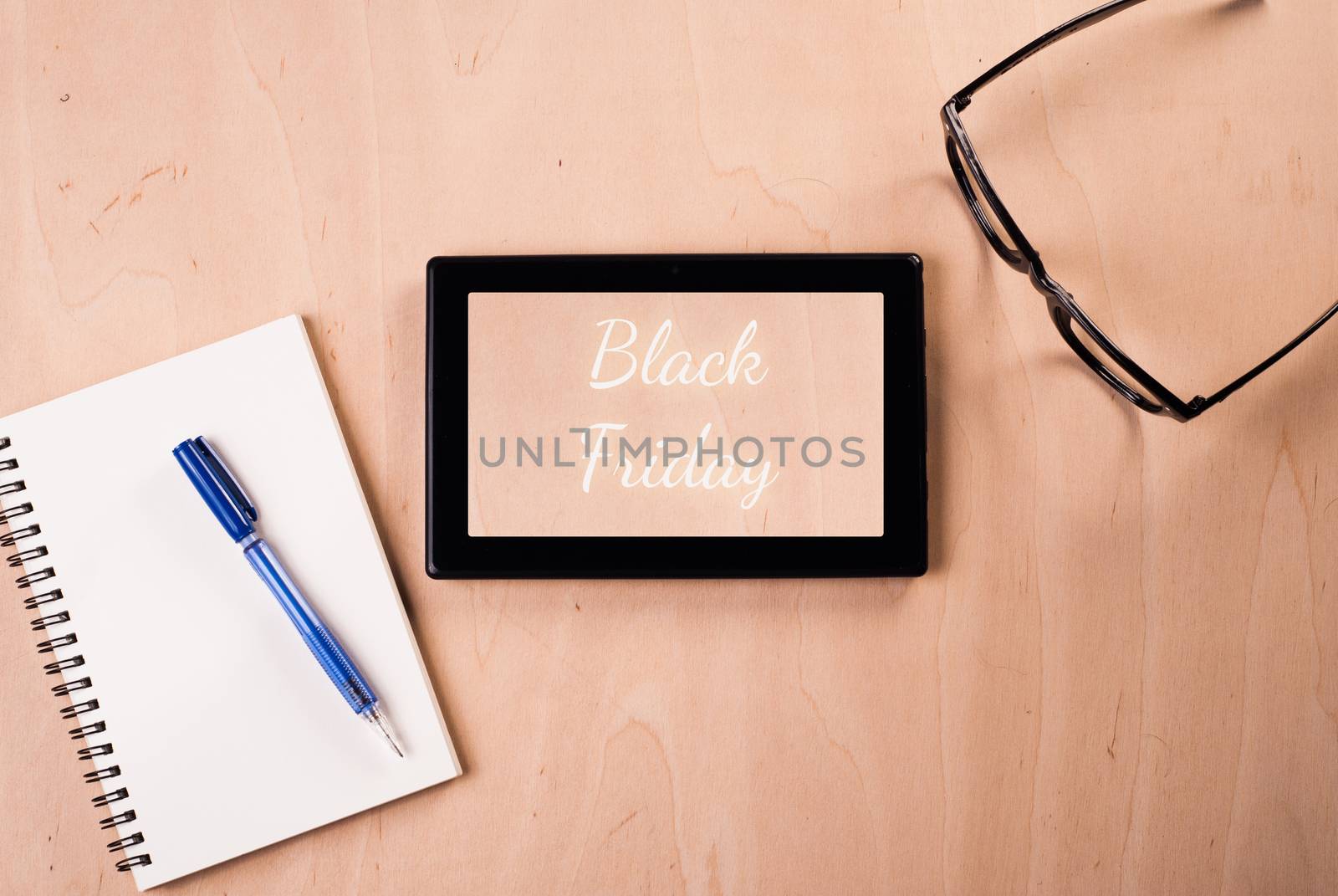 Digital tablet with the inscription: "Black Friday", the subject lay on a wooden table: glasses, Notepad, pen, conceptual illustration for shop advertising