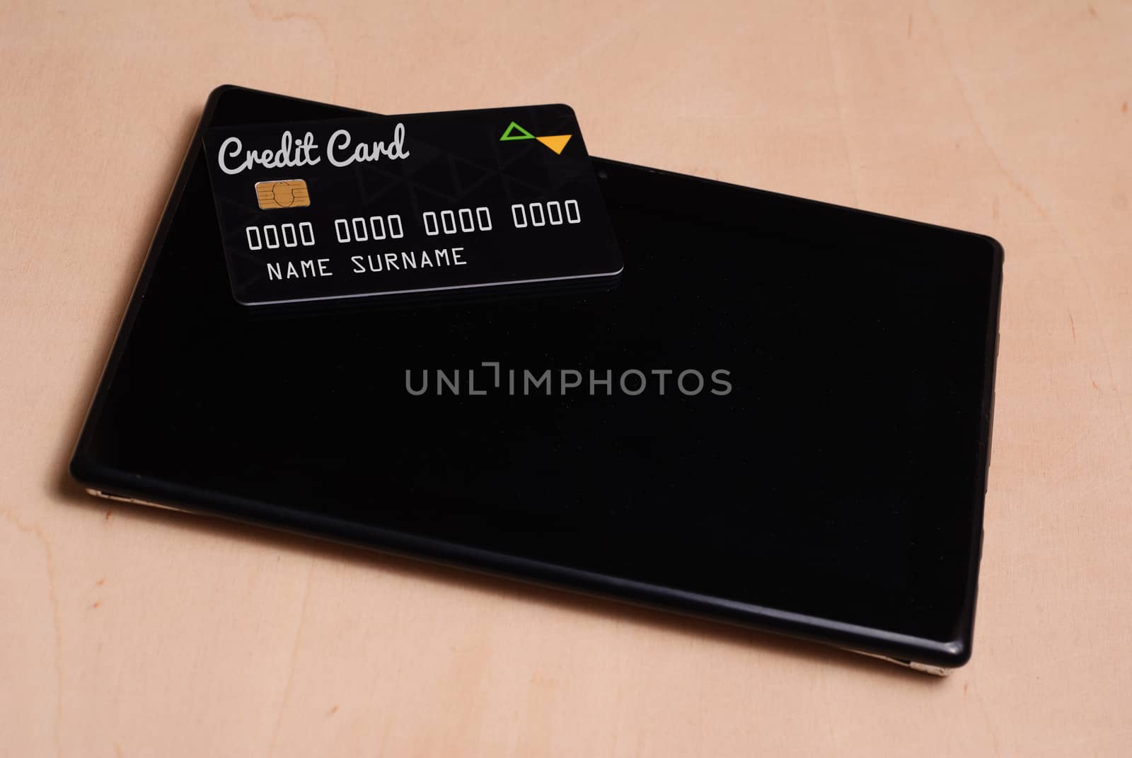 Black credit card is on a black electronic tablet, shopping online,