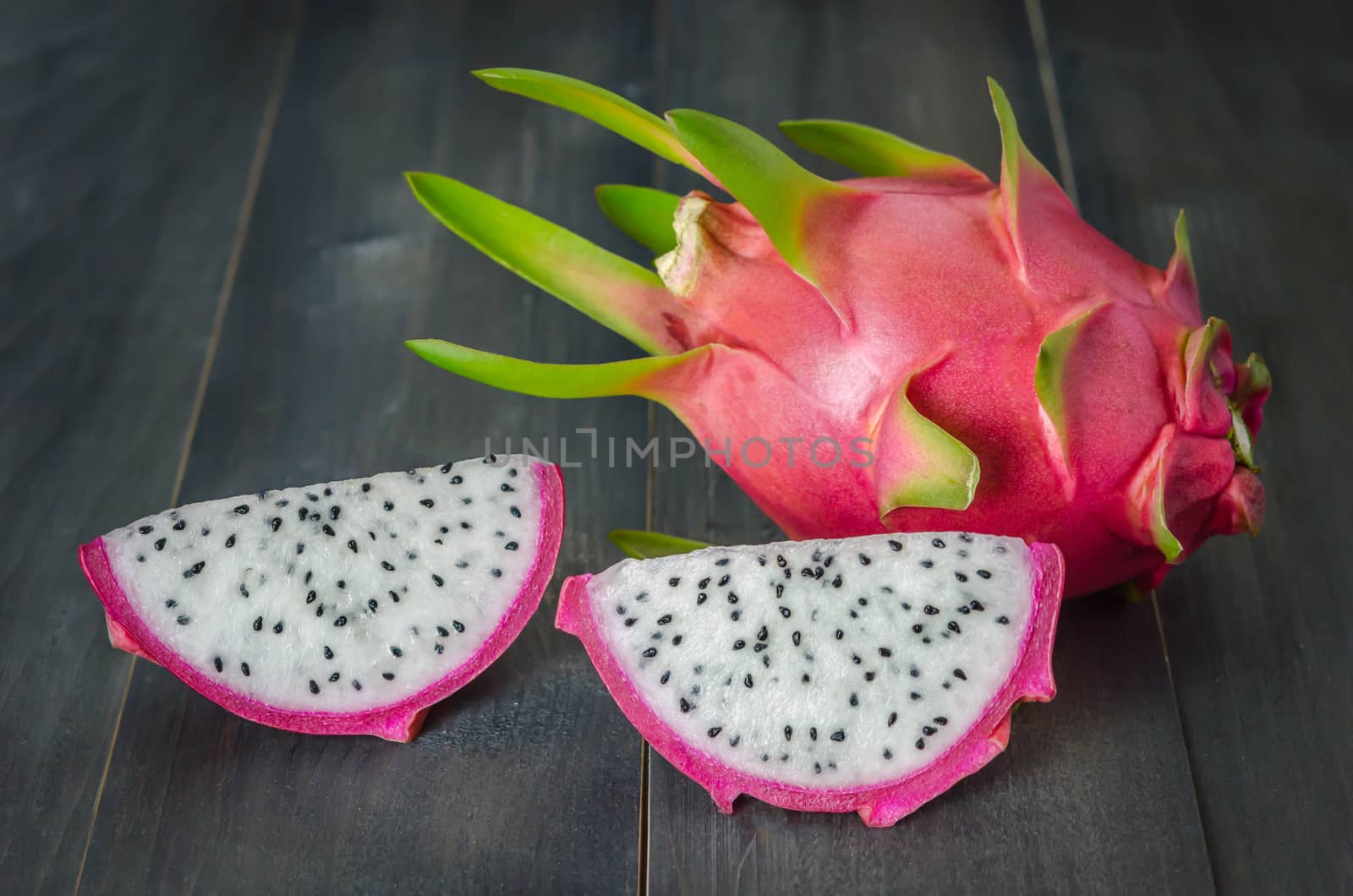 Ripe Dragon fruit or Pitaya with slice on wooden background , still life