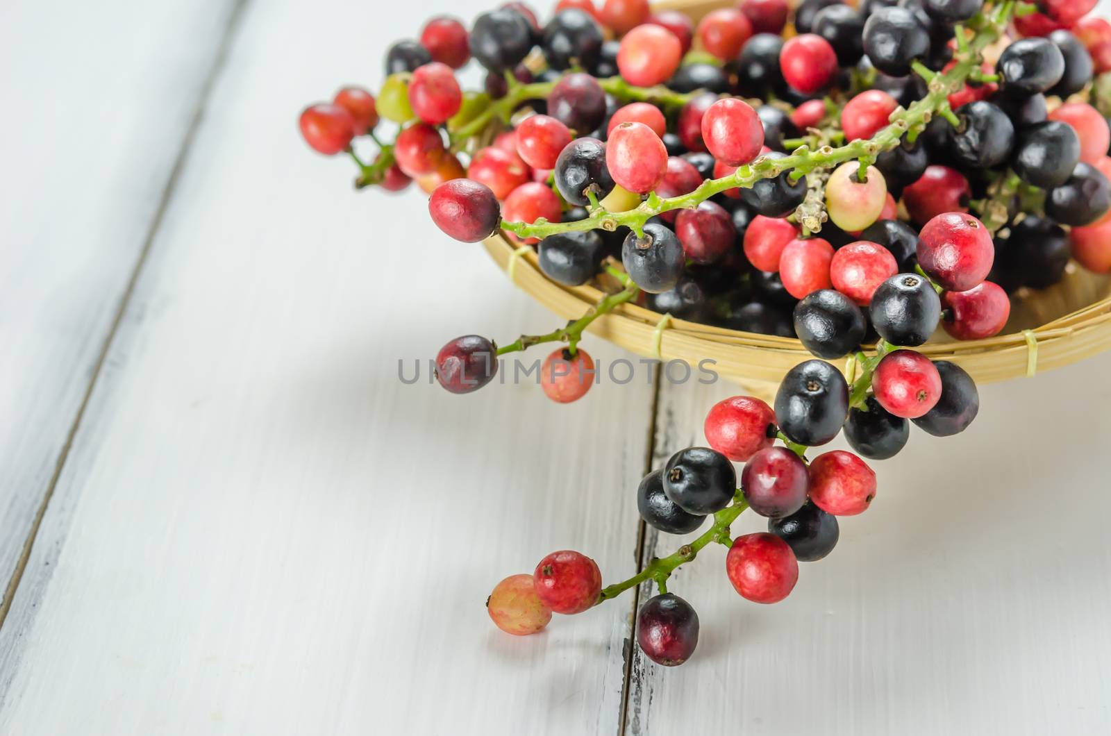 Thai Blueberry in bamboo basket over wooden background