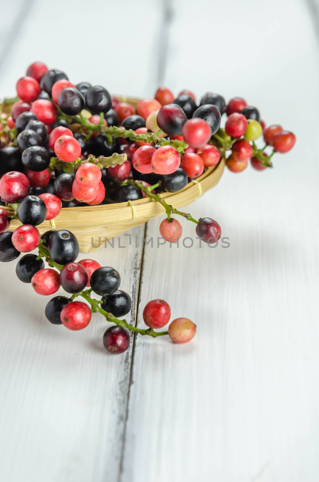 Thai Blueberry in bamboo basket over wooden background