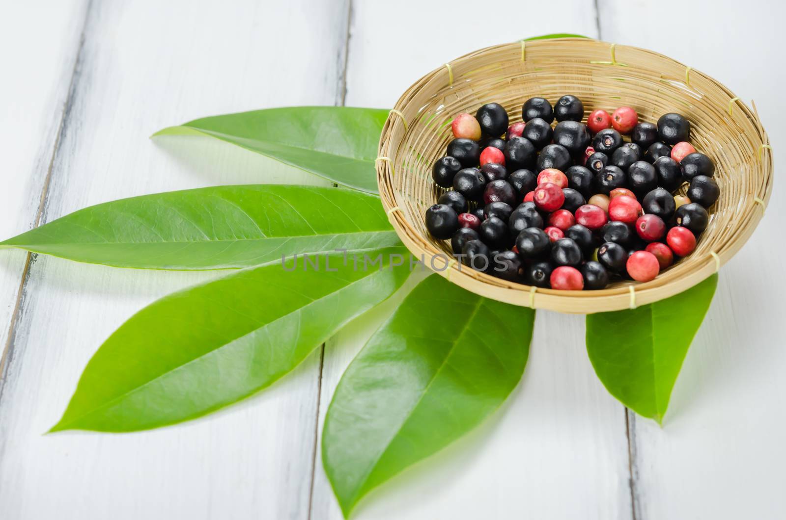 Thai Blueberry in bamboo basket over wooden background , still life
