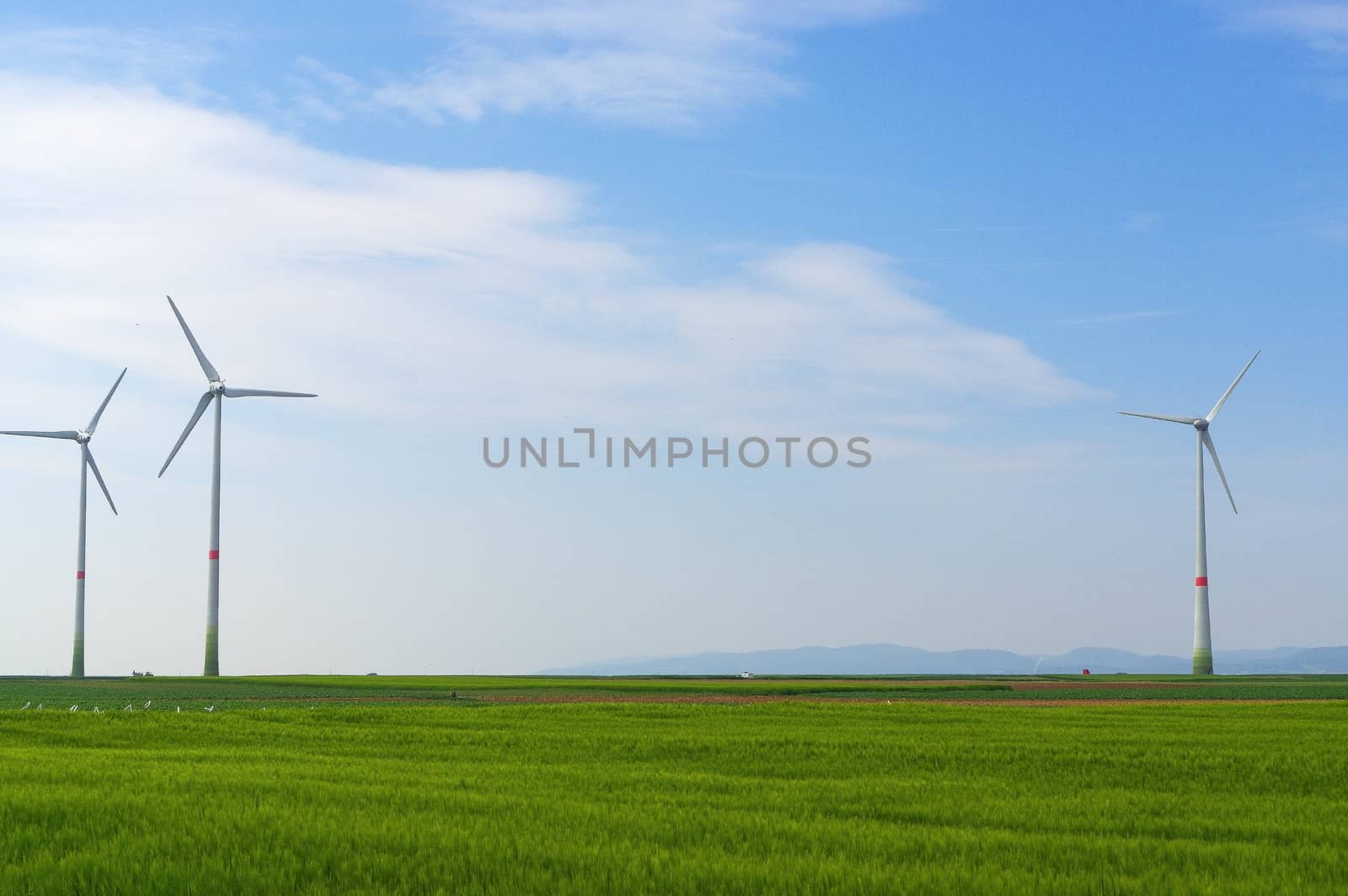 green meadow with Wind turbines generating electricity by evolutionnow