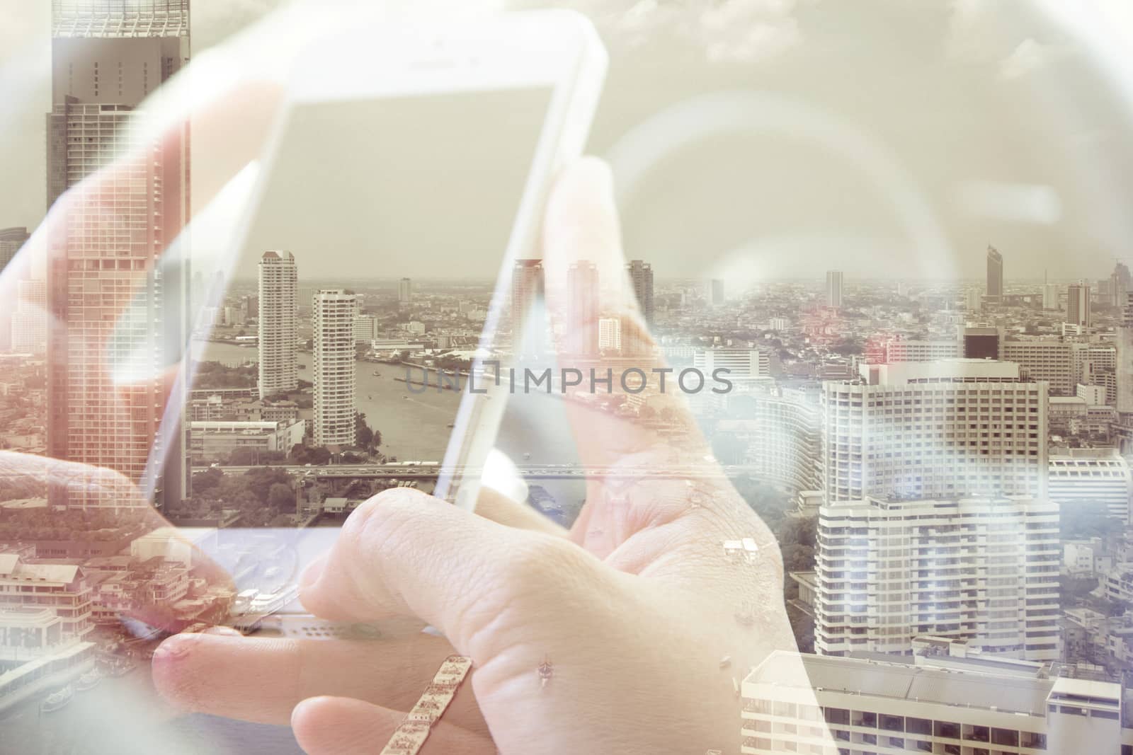 Double exposure of man using smart phone and cityscape background ,Business technology concept.