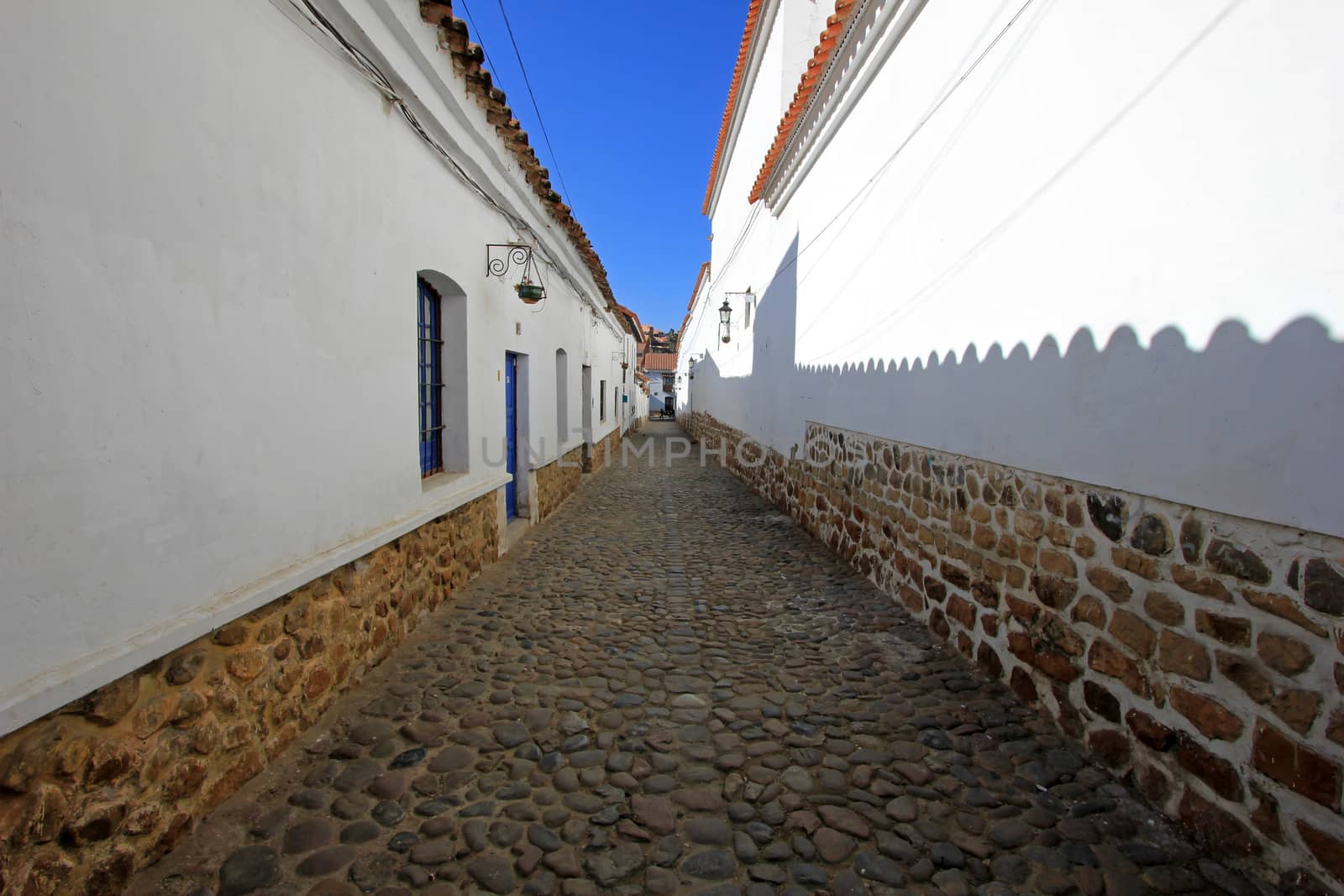 Cobblestone street and white colonial houses in Sucre, capital of Bolivia.