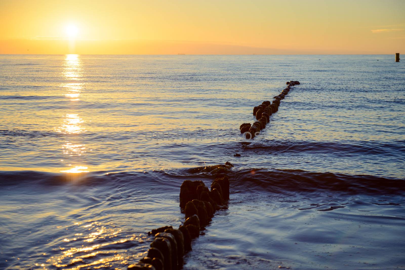 Breakwaters in the Baltic sea over the sunset in summer
