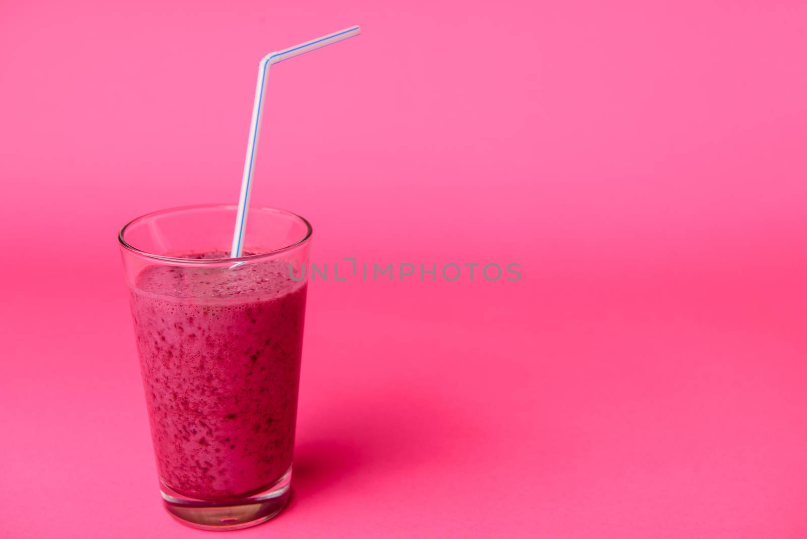 Blueberry smoothie with fresh berries, chia seeds and banana for breakfast on pink background, selective focus