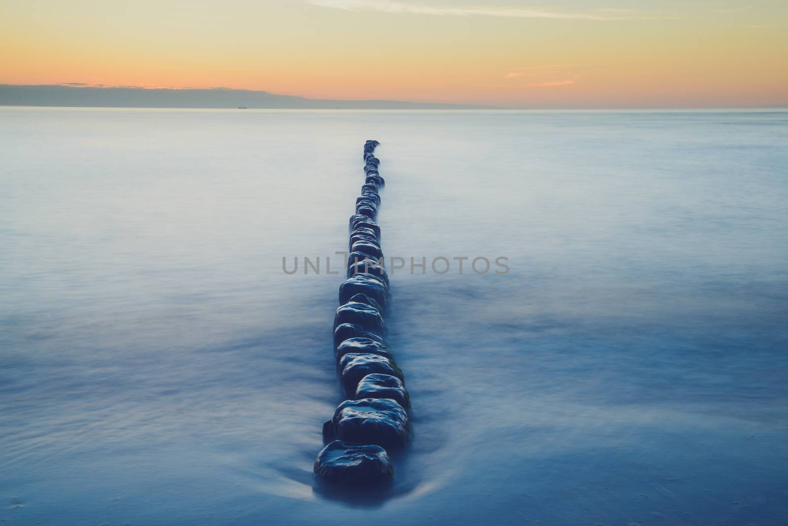 Breakwaters in the Baltic sea over the sunset in summer