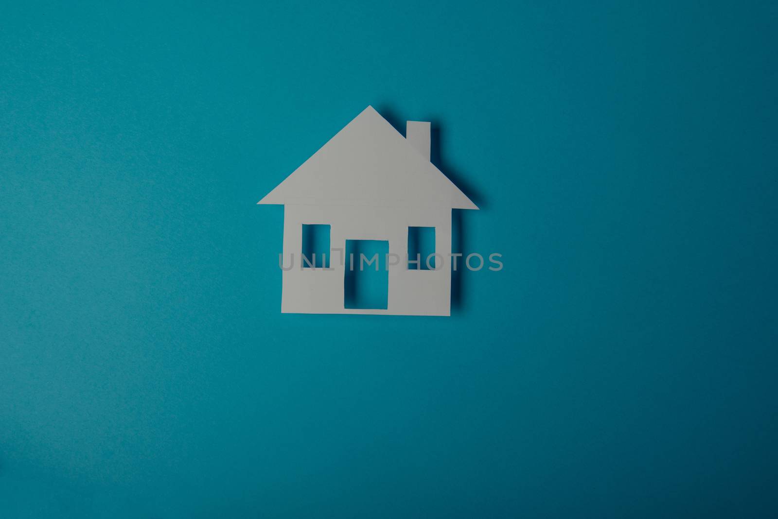 House shaped paper cutout on on blue background