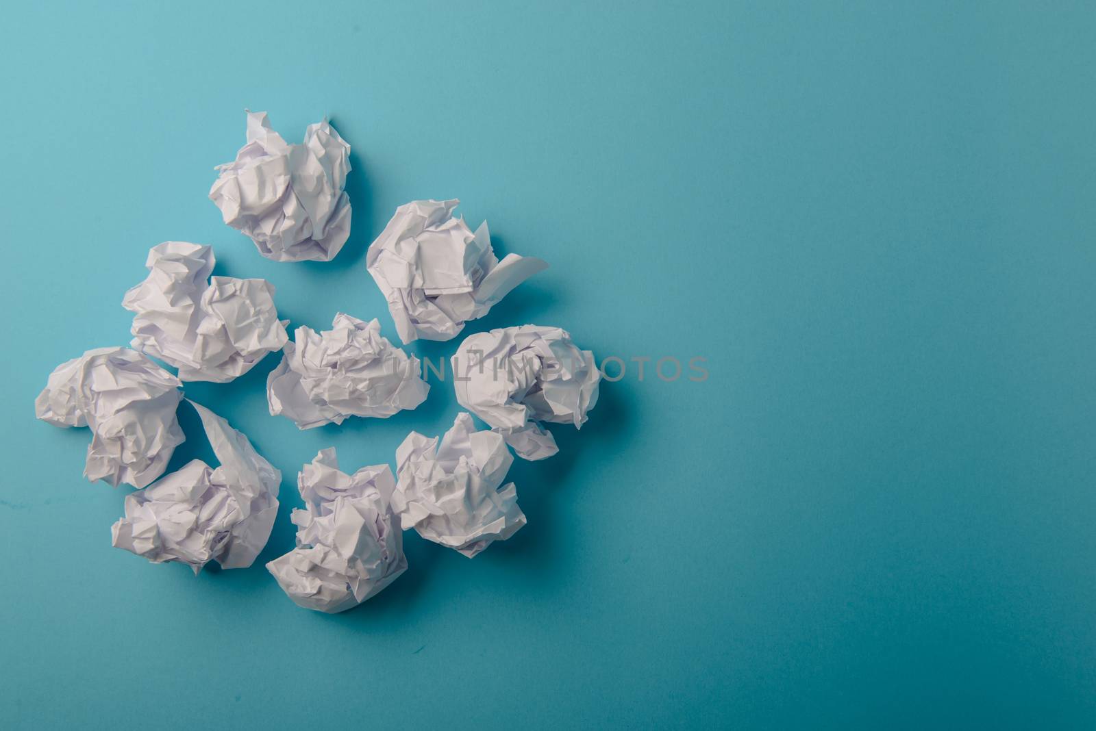 crumpled paper ball isolated on a blue background