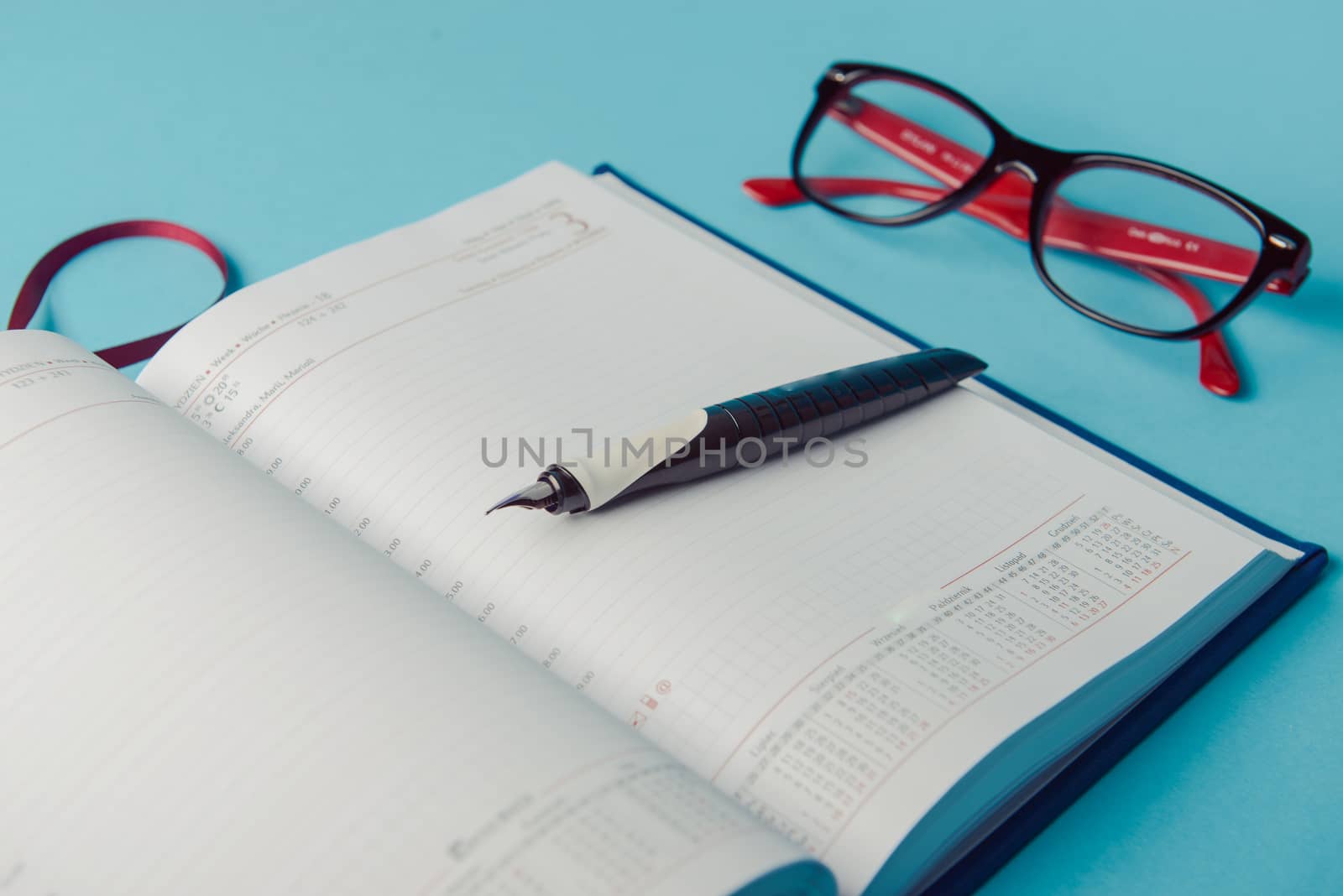 notebook on blue background. open diary and pen to record