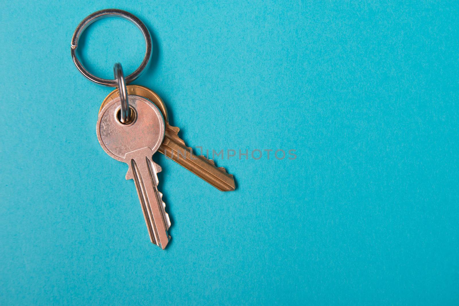 silver house key lying on blue paper background