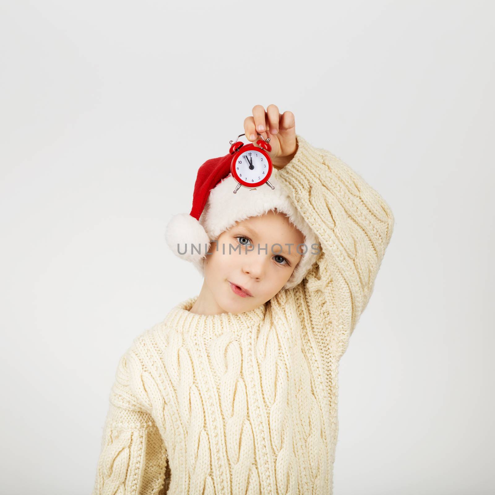 Portrait of happy joyful beautiful little boy wearing Santa hat against white background. New Year and Christmas concept