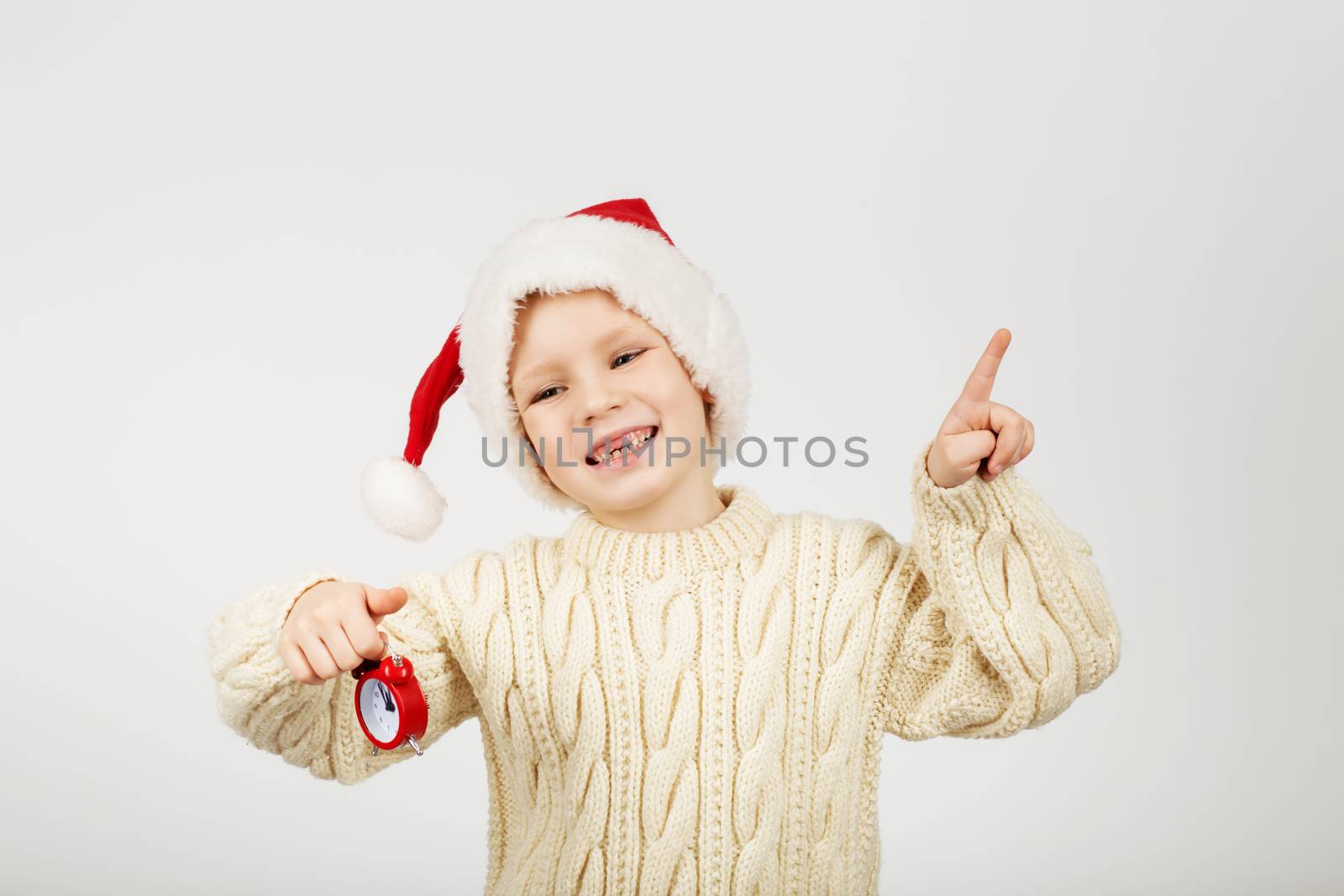 Portrait of happy joyful beautiful little boy wearing Santa hat against white background. New Year and Christmas concept