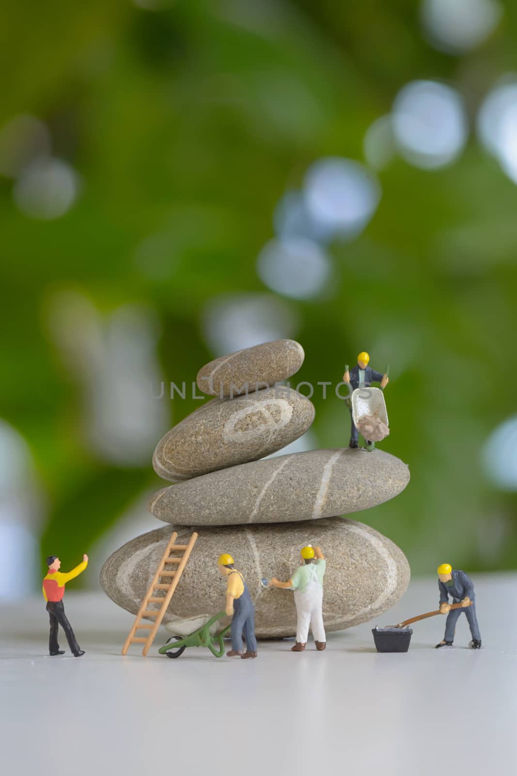 Pebbles stack and figurines of construction workers