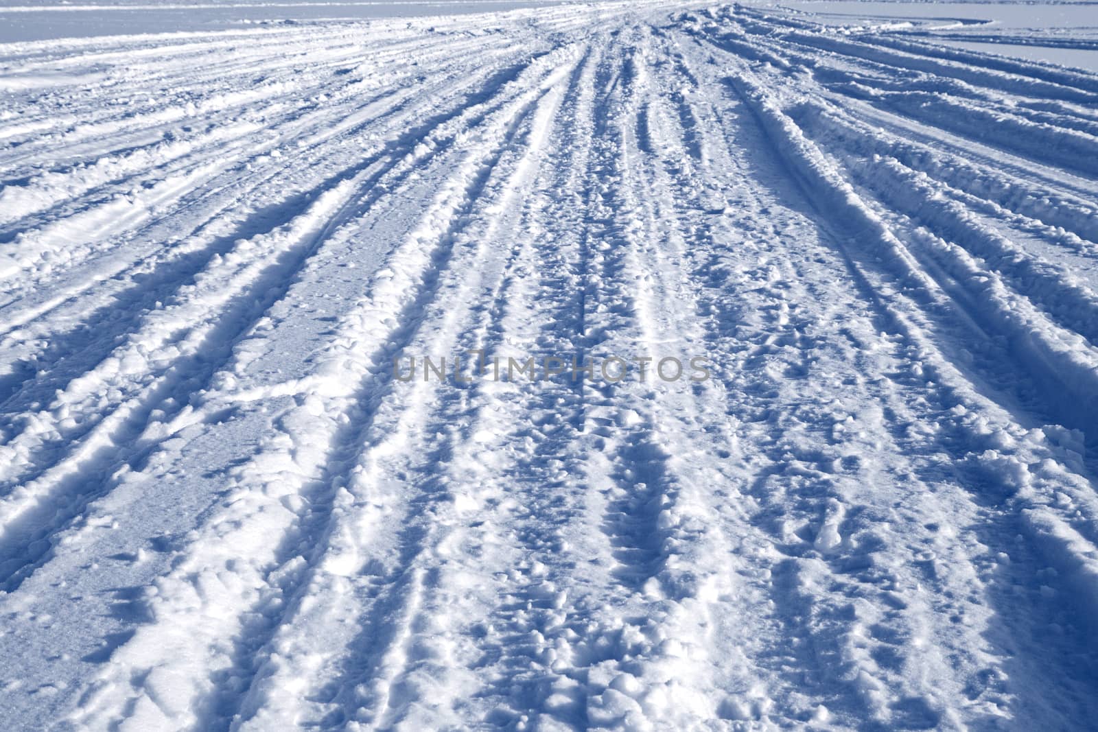 Many ski and car tracks on snow