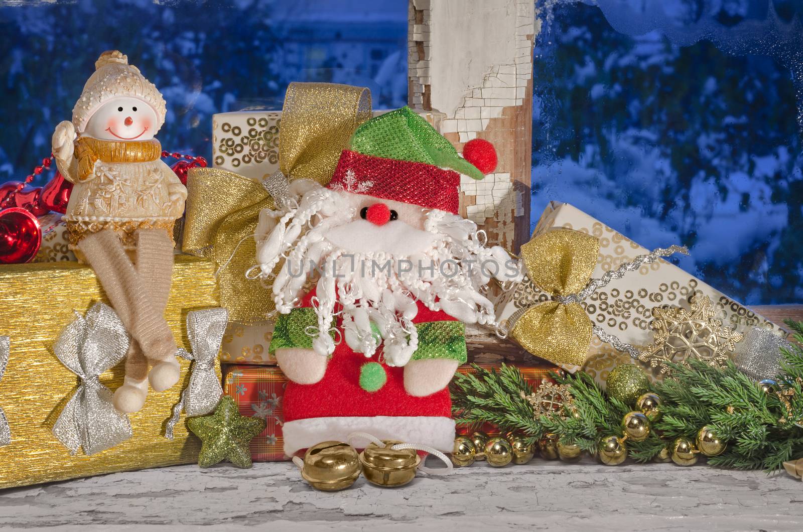 Christmas composition with Santa Claus and snowman on an old window in the evening