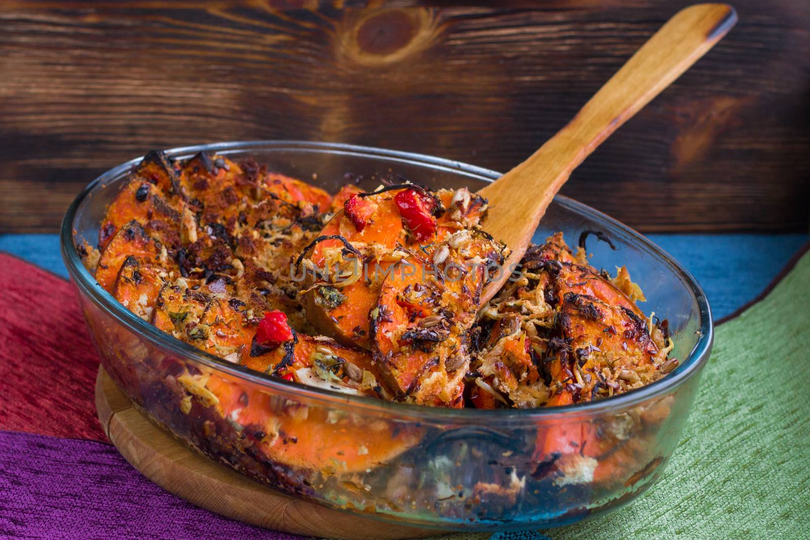 Vegetarian dish of orange pumkin, mixed vegetables, herbs and cheese baked in oven