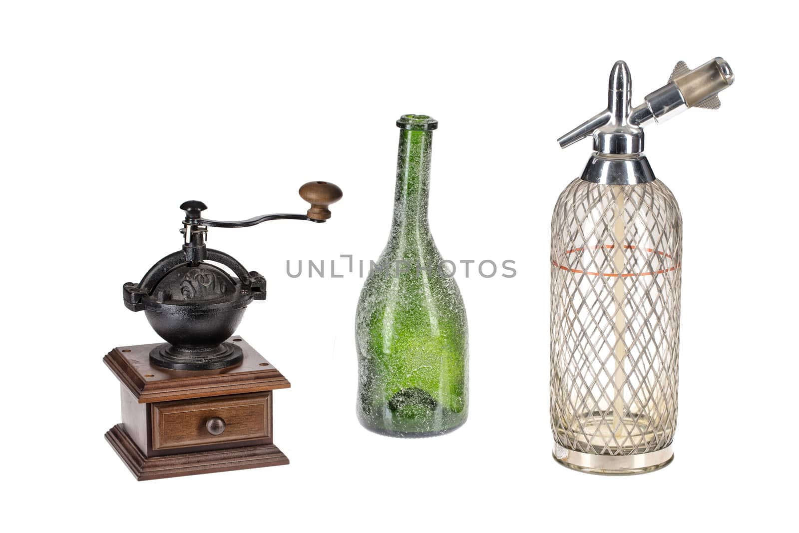 Old coffee mill, green bottle and glass siphon on an isolated studio background
