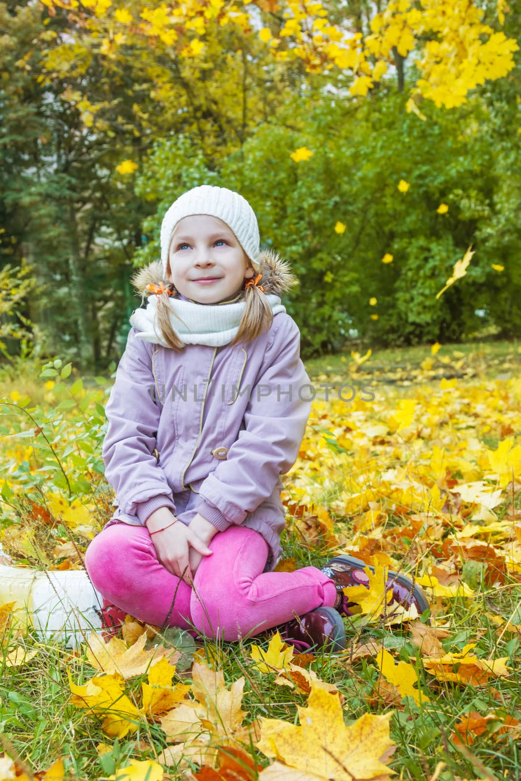 Cute girl under falling yellow leaves dreaming