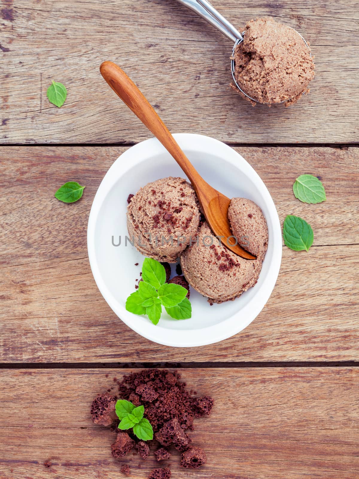 Chocolate ice cream in white bowl with fresh peppermint leaves a by kerdkanno