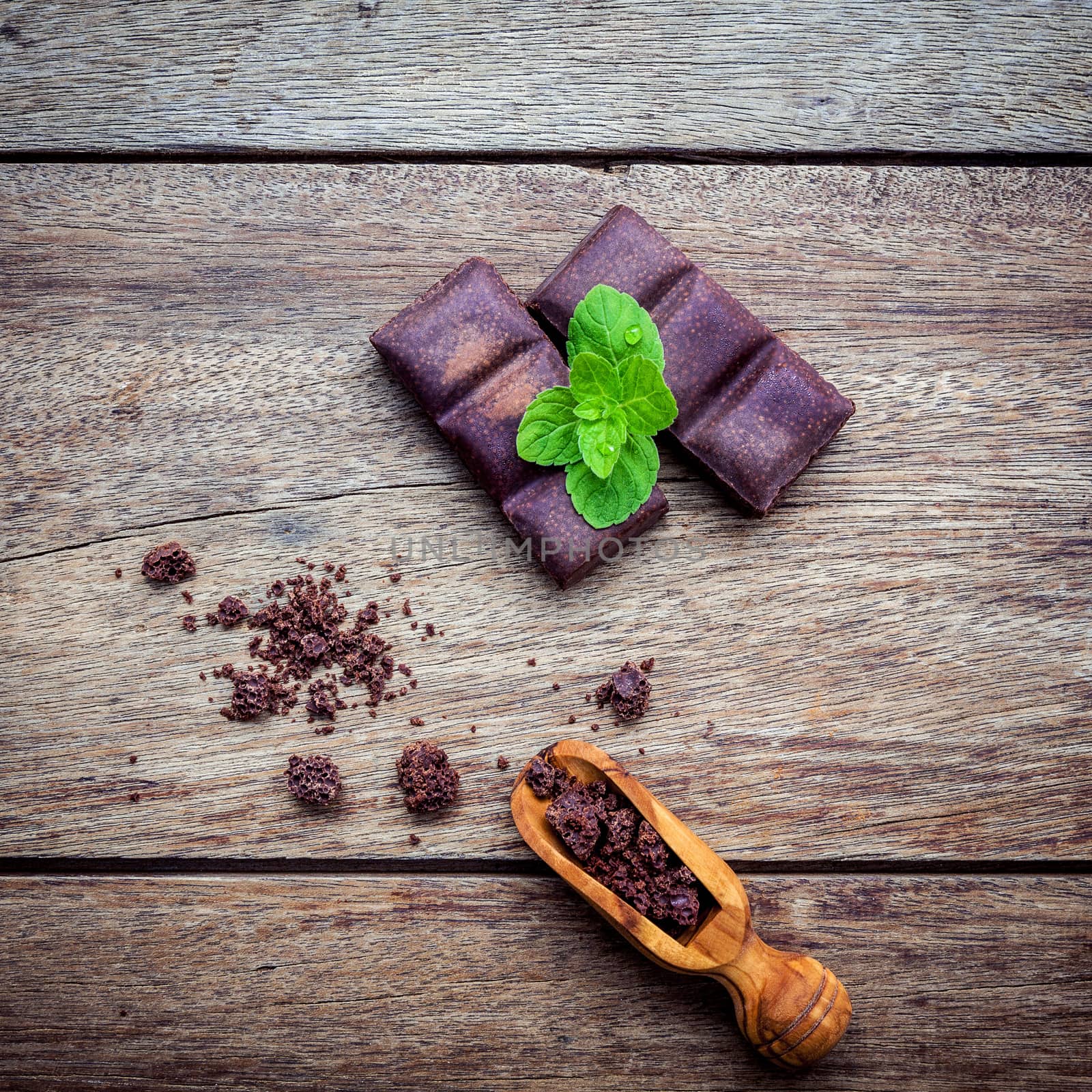 Chocolate background and dessert menu. Ingredients for bakery chocolate bar with mint ,chocolate powder in wooden spoon setup on dark shabby wooden background.