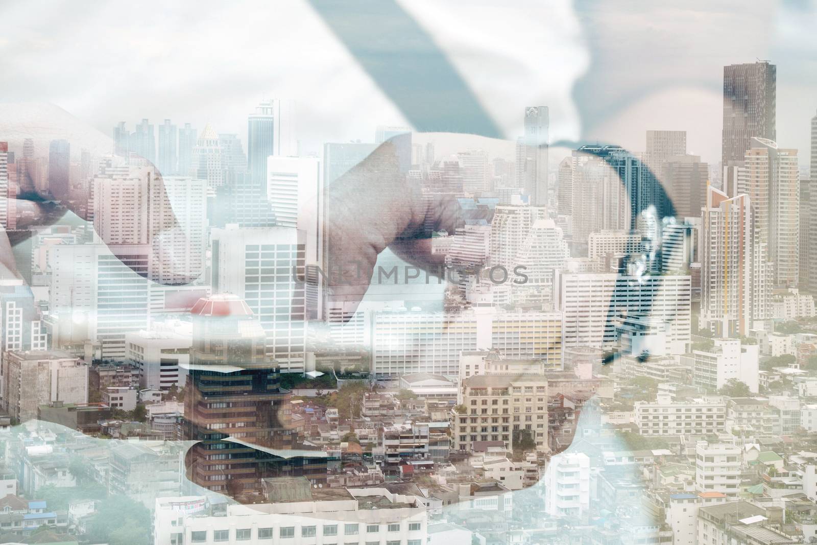 Double exposure of using smart phone and cityscape background ,Business technology concept.