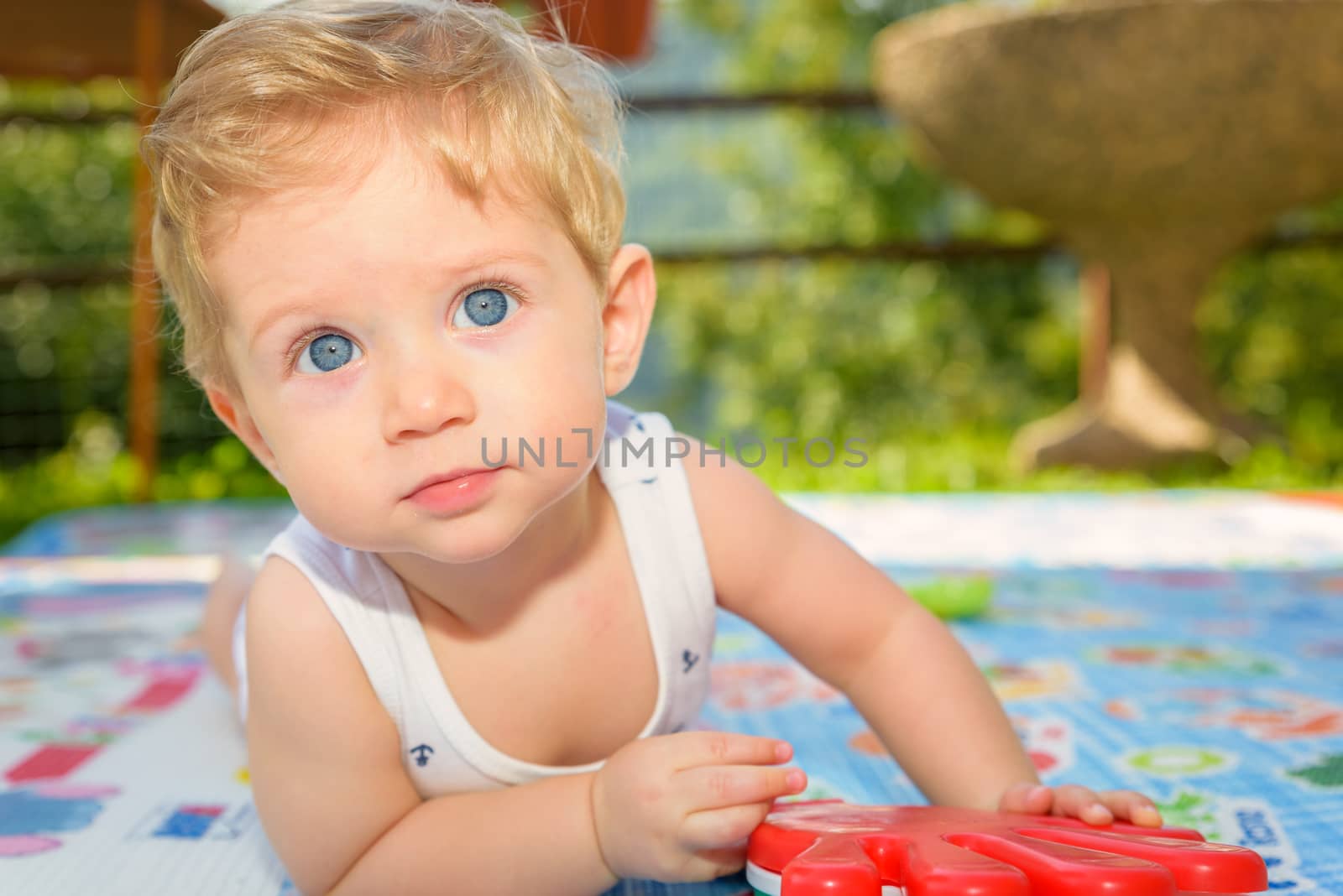 Beautiful baby boy eight month old crawling in the garden,close up.