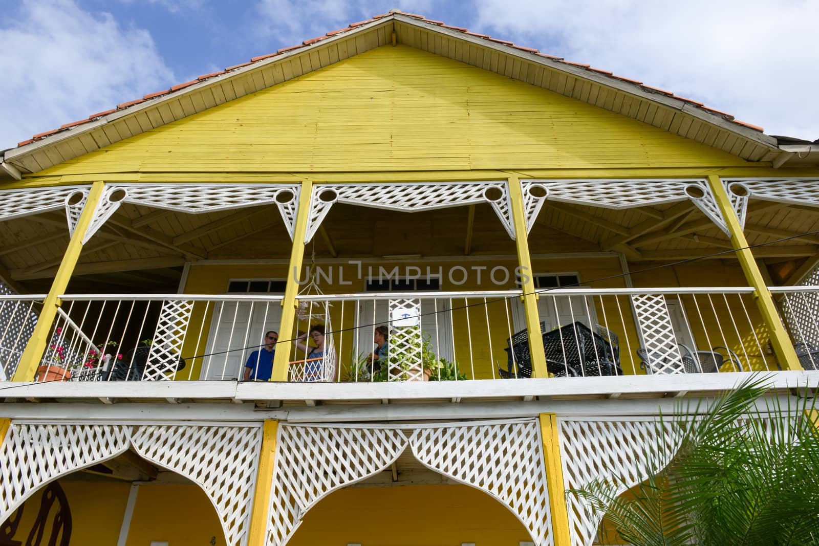 Cienfuegos, Cuba - 18 january 2016: People speaking on the balcony of a colonial mansion at the old town of Cienfuegos, Cuba