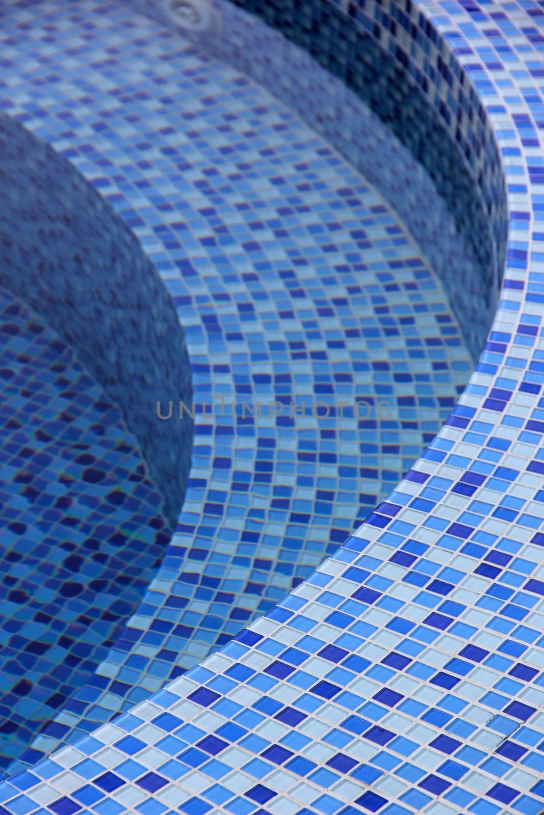 Curved steps at the swimming pool with blue tile mosaic