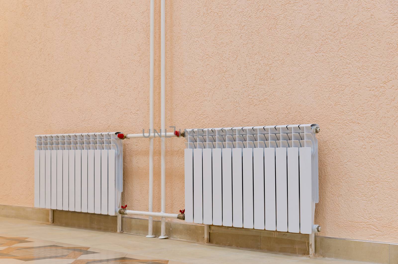 White new radiator on a pink wall